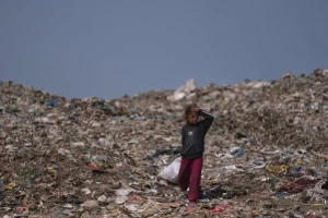 Niña palestina busca objetos reutilizables en un vertedero de Deir al Balah, Gaza, el 23 de julio de 2026