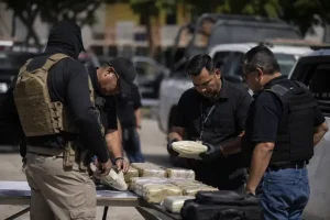 Elementos de seguridad revisan paquetes asegurados durante un operativo en Tapachula