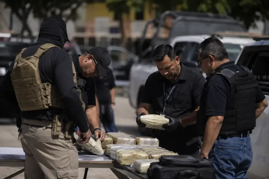 Elementos de seguridad revisan paquetes asegurados durante un operativo en Tapachula