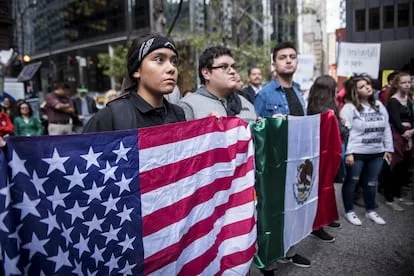 Integrantes de la comunidad mexicana protestan con banderas de Mexico y Estados Unidos en Illinois