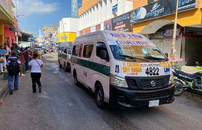 Colectivos de transporte publico circulan en una calle de Tuxtla Gutierrez