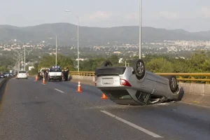 Automovil volcado en un puente urbano de Tuxtla Gutierrez con personal de emergencia a distancia