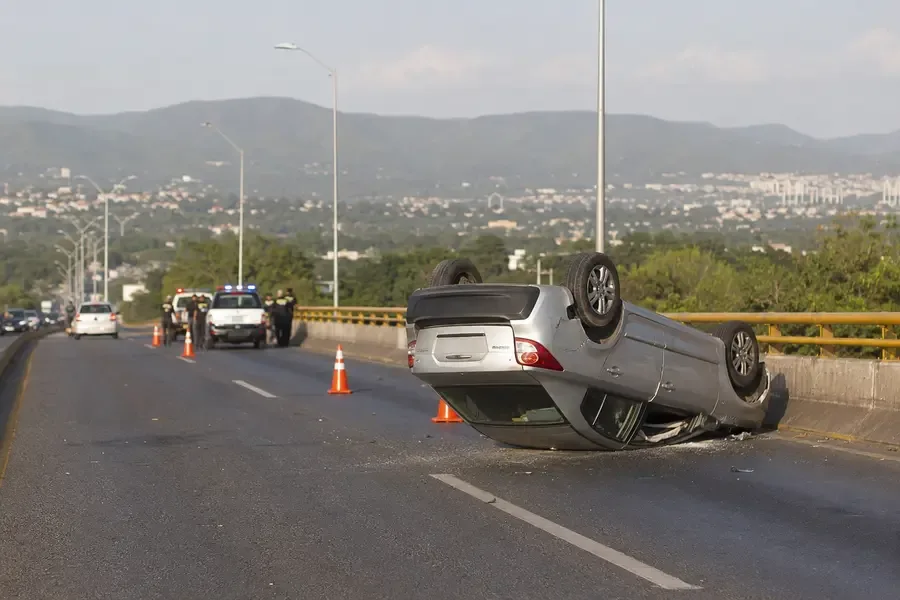 Automovil volcado en un puente urbano de Tuxtla Gutierrez con personal de emergencia a distancia