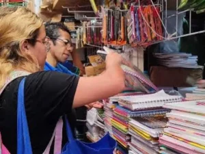 Personas compran cuadernos y útiles escolares en un comercio de Tuxtla