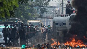 Agentes de policía frente a una barricada incendiada durante la crisis en Myanmar