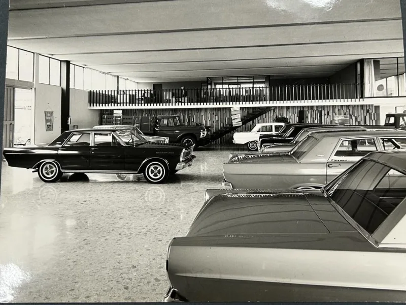 Agencia automotriz histórica con vehículos en exhibición