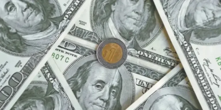 Billetes mexicanos y dólares en una mesa de operación cambiaria