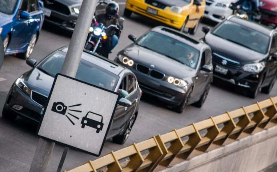 Señal de cámara para fotomultas junto a vehículos en circulación